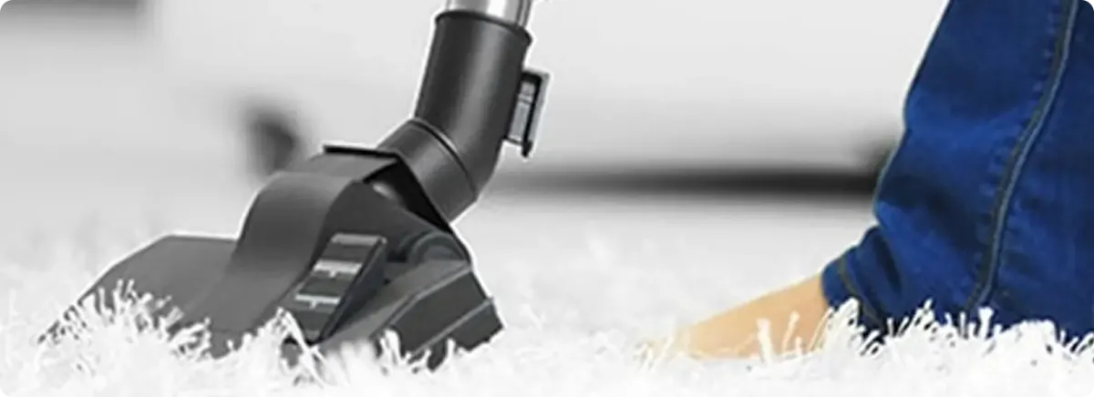 Close-up of a professional vacuuming a white carpet in East Greenbush.
